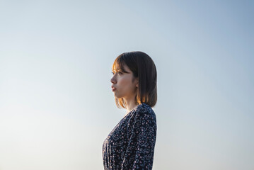 夕暮れの海にいる女性