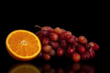 Orange and grapes on a black background.