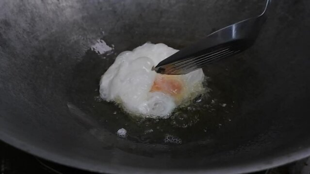 How to fry a fried egg in a frying pan with hot oil and turn the omelet back and forth with a spatula.