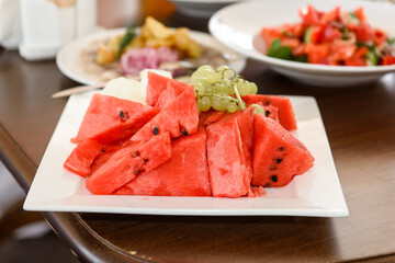 Watermelon and grapes on a dessert plate. Healthy vitamin fruits on the table.