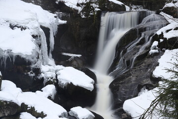 triberg waterfalls in winter with snow. Long exposure in fog, cold ice and bad weather in the Black...