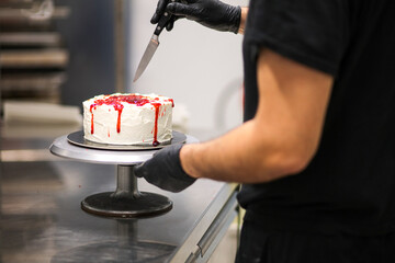 designer chef decorating white red bloody horror crime cake for halloween party - obrazy, fototapety, plakaty