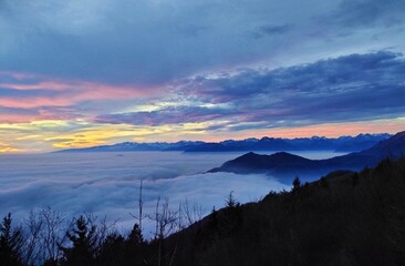 Fog on the plain of Friuli and view of Piancavallo and the Alps at sunset from Mount Bernadia in Tarcento