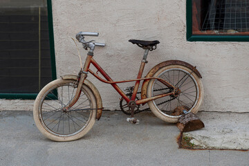 Fototapeta na wymiar Old red retro bike for children