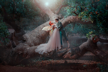  sexy man elf in love embraces gentle fantasy woman fairy. Family standing on branch of green tree....