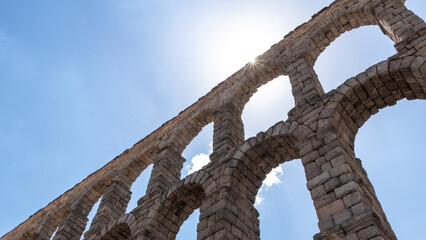 Ancient Roman aqueduct on Plaza del Azoguejo square and old building towns in Segovia, Spain
