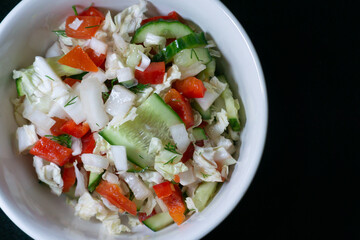 Vegetarian salad with tomato, lettuce, cucumber and onion. bowl with vegetables close up