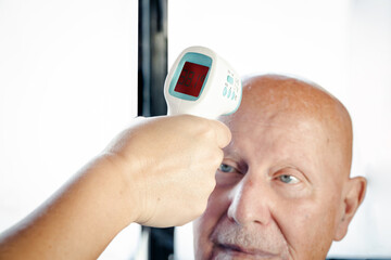 taking the temperature with a digital thermometer to an elderly person