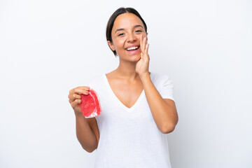 Young hispanic woman holding a piece of meat isolated on white background shouting with mouth wide open