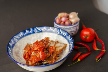 Tomato salted fish. Onions, tomatoes and chilies. black background.