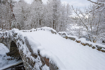 Snowy arch bridge in a winter landscape