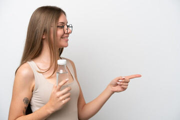 Young Lithuanian woman with a bottle of water isolated on white background pointing to the side to present a product