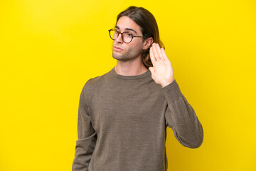 Caucasian handsome man isolated on yellow background making stop gesture and disappointed