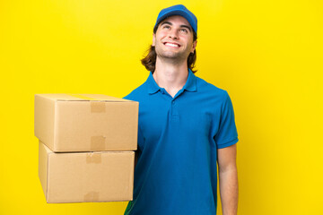 Delivery handsome man isolated on yellow background thinking an idea while looking up