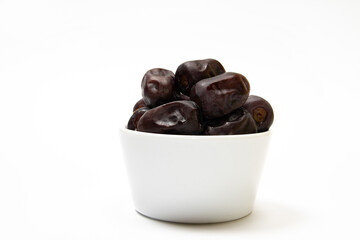 Fresh dates fruit in a white bowl on white background