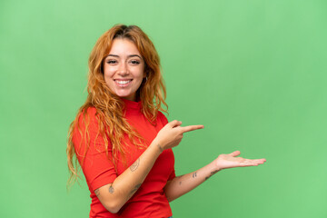 Young caucasian woman isolated on green screen chroma key background holding copyspace imaginary on...