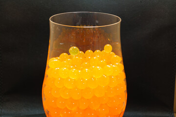 growing Orbeez in a glass. multicolored balls that grow in water.