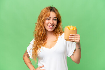 Young caucasian woman holding fried chips isolated on green screen chroma key background