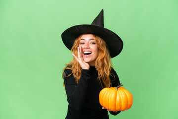 Young caucasian woman costume as witch holding a pumpkin isolated on green screen chroma key...