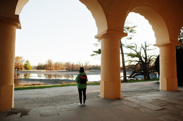 Back of woman with bakcpack stand under arch Lednice minaret, Czech Republic.
