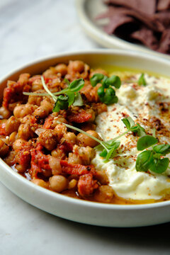 Chickpeas and tomato sofrito with hummus in a white bowl