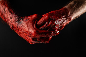 Man rubbing bloody hands on black background. © Михаил Решетников