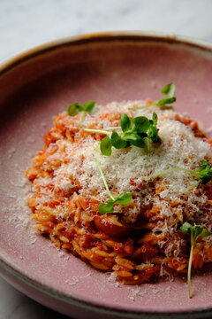 Cherry tomato sugo risoni in a pink bowl