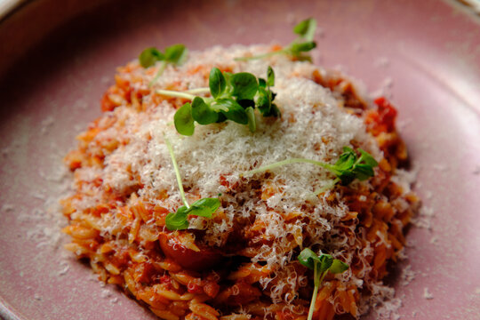 Cherry tomato sugo risoni in a pink bowl