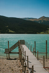 Wooden pier at Resia Lake, in the Alps in Italy.
