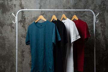Plain t-shirts of various colors are hung on the clothes rack.