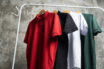 Plain t-shirts of various colors are hung on the clothes rack.