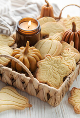 Fototapeta na wymiar Cookies shaped like pumpkin and leaves on rustic wood background