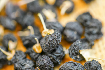 There are many naturally dried black wolfberries on the table