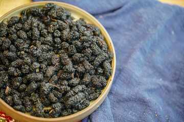 There are many naturally dried black wolfberries on the table