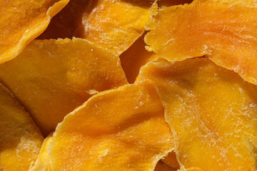Dried mango slices close-up on a white. Top view. Closeup. Mango chips background. Dehydrated crispy fruit slices, pieces. Heap of sun-dried yellow fruit. Healthy meal. Top view, flat lay. 4K Footage