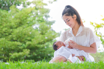 Beautiful breastfeeding mother, a family in an Asian garden