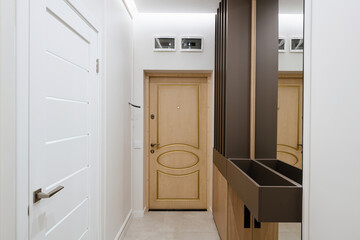 bright corridor with dark wooden furniture and a mirror