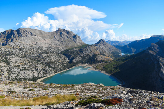 View of Puig Major and Embassament de Cúber in Mallorca, Spain. The reservoir is in the Serra de Tramuntana mountain range in front of the island's highest peak, with dramatic clouds in the background