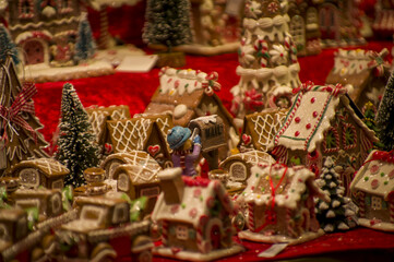 Naklejka premium Advent Bazaar Stalls with glass, wooden, ceramic christmas souvenirs in shops. Close up of festive decorations for tree in winter street night market during new year's holiday. Illuminated fair kiosk