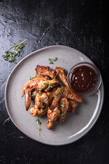 Barbecue chicken wings with sauce on black table