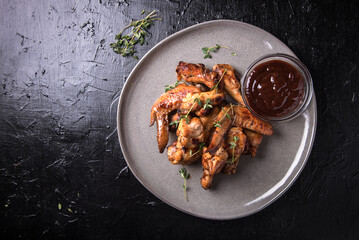 Barbecue chicken wings with sauce on black table
