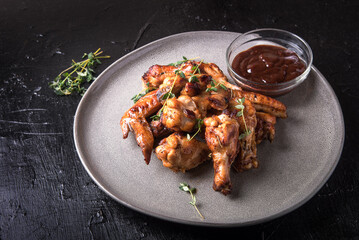 Barbecue chicken wings with sauce on black table