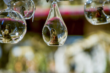 Advent Bazaar Stalls with glass, wooden, ceramic christmas souvenirs in shops. Close up of festive decorations for tree in winter street night market during new year's holiday. Illuminated fair kiosk