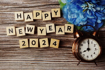 Happy New Year 2023 with alarm clock on wooden background