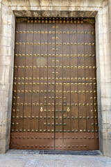 A wooden door with large brass rivets in Cordoba, Andalusia, Spain
