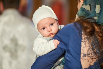 A small child at a baby christening ceremony in a church. .Baptism of the newborn. The sacrament of...