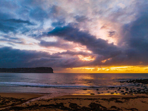 Drizzly moody sunrise seascape with cloud filled sky