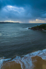 Fototapeta na wymiar Sunrise seascape with overcast sky and rain clouds