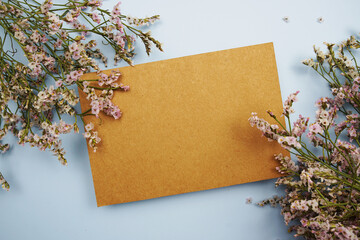 Empty card for text message and flower decoration on blue background