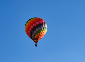 Color hot air balloon flying through the blue sky.
